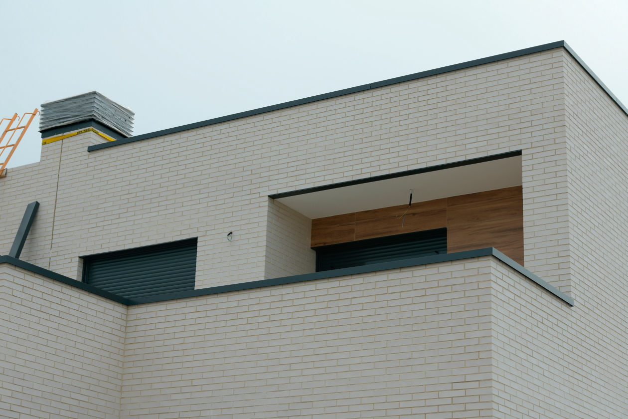 Remates de aluminio en fachada y chimenea con cierre enrollable