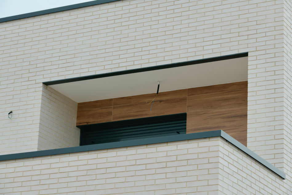 Remates de aluminio en balcón con cierre enrollable y detalles en madera