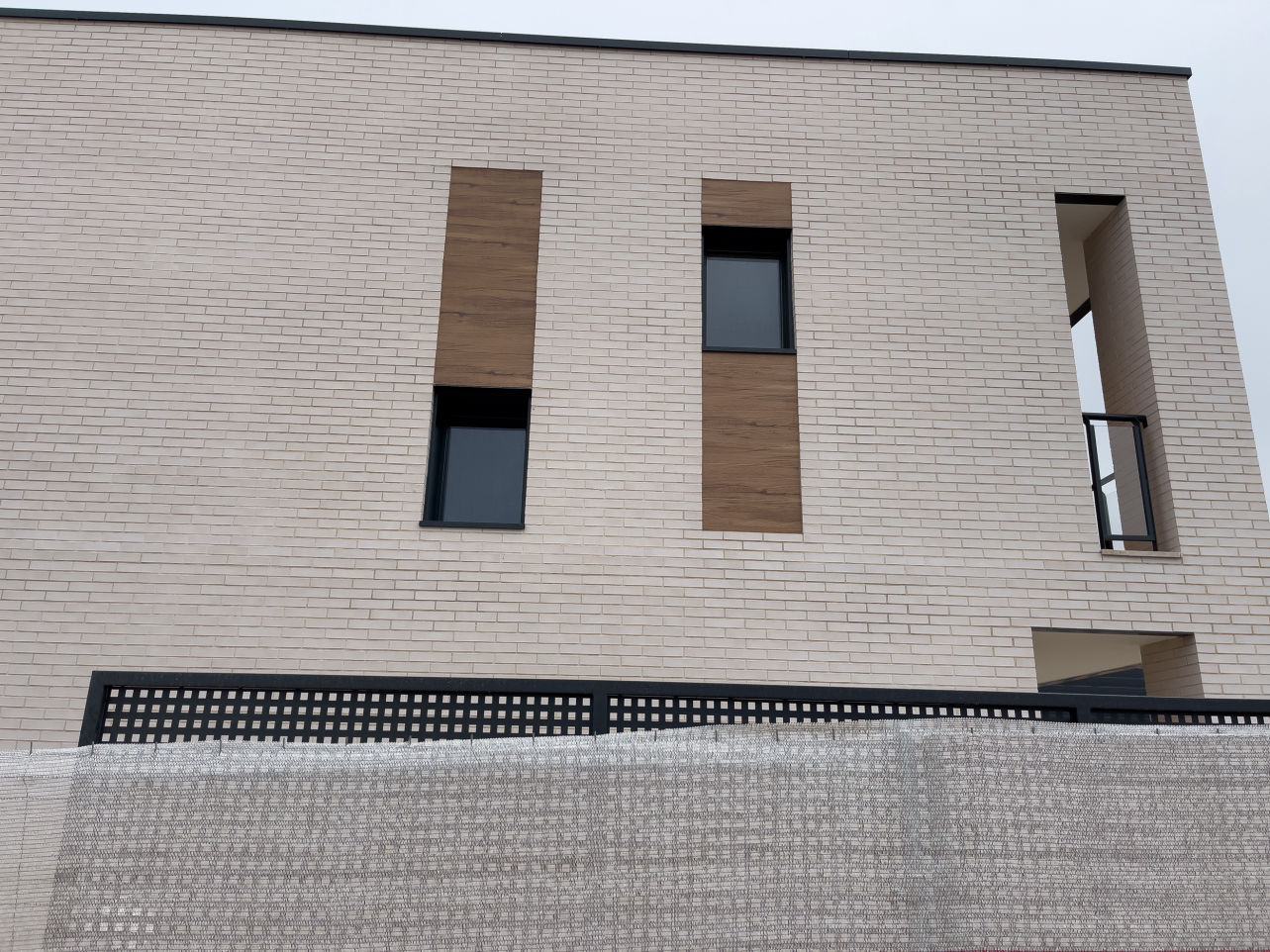 Ventanas con remates de aluminio en fachada de ladrillo blanco